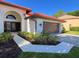 Elegant home exterior with a tile roof, arched entryway, and lush landscaping at 4804 Longwater Way, Tampa, FL 33615