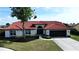Charming single-story home with a red tile roof, arched entry, and lush landscaping for enhanced curb appeal at 4804 Longwater Way, Tampa, FL 33615