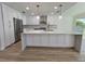 Gourmet kitchen featuring white cabinets, marble countertops, stainless steel appliances, and modern pendant lights at 4804 Longwater Way, Tampa, FL 33615