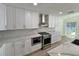 Stylish kitchen with white cabinets, stainless steel appliances, marble backsplash and countertops, and modern fixtures at 4804 Longwater Way, Tampa, FL 33615
