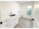 Clean laundry room with modern finishes, including white cabinets and updated fixtures at 4804 Longwater Way, Tampa, FL 33615