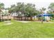 Community playground with covered picnic area, benches, and play structures surrounded by a well-maintained lawn at 4804 Longwater Way, Tampa, FL 33615