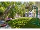 Lush backyard featuring artificial turf, storage shed, and mature trees at 522 James St, Dunedin, FL 34698