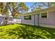 A beautifully manicured backyard with lush artificial grass, a storage shed, and patio furniture at 522 James St, Dunedin, FL 34698