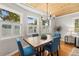 Dining area with hardwood floors, windows with shutters and rustic table with blue chairs at 522 James St, Dunedin, FL 34698