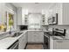 Well-lit kitchen showcasing stainless steel appliances, white cabinets, and marble countertops at 522 James St, Dunedin, FL 34698