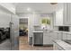 Bright kitchen featuring stainless steel appliances, white cabinetry, and a view to the Gathering room at 522 James St, Dunedin, FL 34698