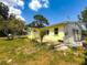 Backyard area featuring a small patio, trees, and a sunny sky view at 5995 59Th N Way, St Petersburg, FL 33709