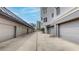 View down a concrete drive between rows of garages showing modern condo building at 600 Garrison Cove Ln # 2B, Tampa, FL 33602