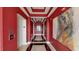 Hallway with red walls featuring elevator access and modern artwork with decorative lighting at 600 Garrison Cove Ln # 2B, Tampa, FL 33602