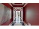 Long hallway with red walls and modern artwork, leading to a large window at 600 Garrison Cove Ln # 2B, Tampa, FL 33602