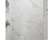 Close-up of shower wall with long white tiles with grey veining and brushed nickel hardware at 7313 8Th N Ave, St Petersburg, FL 33710