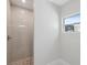 Elegant shower with frameless door, natural stone floor, and bright natural light at 7313 8Th N Ave, St Petersburg, FL 33710