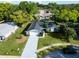 Aerial view of the house showing driveway, and backyard with a tree-lined neighborhood at 7504 Lily Pad Ct, Hudson, FL 34667