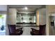 Stylish bar area with dark counter top, mirror backing, and seating for two at 7504 Lily Pad Ct, Hudson, FL 34667