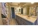 Bathroom with dual sinks, ample counter space, and a shower-tub combo with floral shower curtain at 7504 Lily Pad Ct, Hudson, FL 34667
