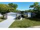Charming single-story home with attached garage, well-manicured lawn, and lush landscaping at 7504 Lily Pad Ct, Hudson, FL 34667