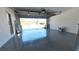 Garage with shiny epoxy floor with ladder, paint and open door at 7504 Lily Pad Ct, Hudson, FL 34667