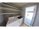Functional laundry room with washer, dryer, shelving, and convenient access to the garage at 7504 Lily Pad Ct, Hudson, FL 34667