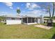 Rear view of the property, highlighting the screened patio and the backyard space with grill and patio at 7553 Sequoia Dr, New Port Richey, FL 34653