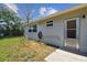 Exterior of home showing well-maintained backyard with mature trees and hose on the side of the house at 7553 Sequoia Dr, New Port Richey, FL 34653