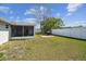 Large backyard with a screened patio and a grill, providing ample space for relaxation and recreation at 7553 Sequoia Dr, New Port Richey, FL 34653