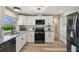 Modern kitchen with granite countertops, white cabinets, black appliances, hardwood floors and modern fixtures at 7553 Sequoia Dr, New Port Richey, FL 34653