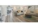 Open-concept living room and dining area with hardwood floors, neutral tones, and views of the backyard at 7553 Sequoia Dr, New Port Richey, FL 34653