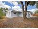 A view of the backyard with a large tree and side view of the home at 7830 Judith Cres, Port Richey, FL 34668