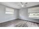 Bright bedroom features wood floors, a ceiling fan, and two windows at 7830 Judith Cres, Port Richey, FL 34668