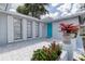 Inviting front entrance featuring a blue door, tiled patio, and decorative potted plants enhancing curb appeal at 7830 Judith Cres, Port Richey, FL 34668