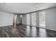 Bright and airy living room featuring wood-look floors, new lighting, and large windows at 7830 Judith Cres, Port Richey, FL 34668