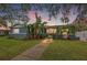 Charming blue home with lush landscaping, walkway, and decorative accents at sunset at 818 37Th Ne Ave, St Petersburg, FL 33704