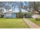 Charming blue home with well-manicured lawn, lush landscaping, and a welcoming walkway leading to the entrance at 818 37Th Ne Ave, St Petersburg, FL 33704