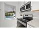 Modern kitchen featuring stainless steel appliances and a window overlooking the pool at 818 37Th Ne Ave, St Petersburg, FL 33704