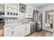 Bright kitchen featuring white cabinets, stainless steel appliances, stylish backsplash, and open shelving at 818 37Th Ne Ave, St Petersburg, FL 33704
