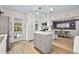 Open kitchen with island, stainless steel appliances, and dining area with blue wallpaper at 818 37Th Ne Ave, St Petersburg, FL 33704