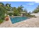 Inviting backyard pool area with pavers, lounge chairs, umbrellas, and lush tropical landscaping for relaxation and enjoyment at 818 37Th Ne Ave, St Petersburg, FL 33704