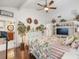 This bedroom has wood floors, a ceiling fan, is decorated with plants and has access to the bathroom at 8305 Palma Vista Ln, Tampa, FL 33614