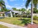 Landscaped front yard of grey home with mature trees and meticulous shrubbery at 8305 Palma Vista Ln, Tampa, FL 33614