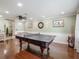 Spacious game room with hardwood floors, ping pong table, ceiling fan and crown molding at 8305 Palma Vista Ln, Tampa, FL 33614