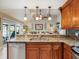 Kitchen showcasing stainless steel sink, wood cabinets, granite countertops, and open view to the living room at 8305 Palma Vista Ln, Tampa, FL 33614