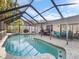 Inviting screened-in pool area with comfortable seating and lush landscaping, perfect for outdoor relaxation at 8305 Palma Vista Ln, Tampa, FL 33614