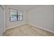 A bright bedroom with neutral carpet and a window overlooking the front yard at 838 Vino Verde Cir, Brandon, FL 33511