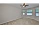 Bedroom with neutral walls, carpet, ceiling fan, and three windows at 838 Vino Verde Cir, Brandon, FL 33511