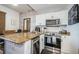 Open kitchen featuring stainless steel appliances, granite counters, and breakfast bar seating at 8800 Bay Pines Blvd # 303, St Petersburg, FL 33709