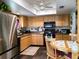 Eat-in kitchen with stainless steel refrigerator and natural wood cabinetry at 8810 41St N St, Pinellas Park, FL 33782
