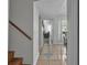 Bright hallway leads to the living area, dining room, and wooden stairs at 337 Rex Pl # E, Madeira Beach, FL 33708