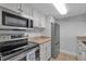 Well-lit kitchen features stainless steel appliances, white cabinets, and tile flooring at 337 Rex Pl # E, Madeira Beach, FL 33708