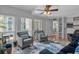 Living room with fireplace, sofa, chairs, ceiling fan, and windows at 337 Rex Pl # E, Madeira Beach, FL 33708